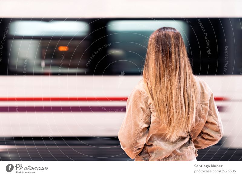 Blondes Mädchen wartet auf ihren Zug Rückansicht gesichtslos unerkannt Bewegung anonym blond Stehen Frau jung Rücken Person Hintergrund Verkehr Transport