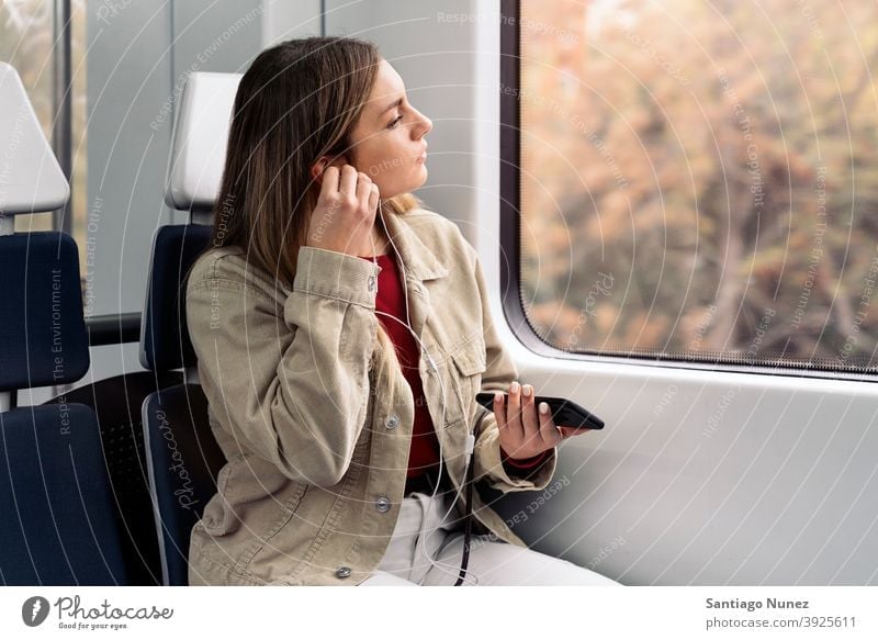 Blondes Mädchen im Zug reisend Kopfhörer Porträt jung 20s Vorderansicht blond hübsch Telefon per Telefon Funktelefon Kaukasier Blick Stehen Frau Smartphone