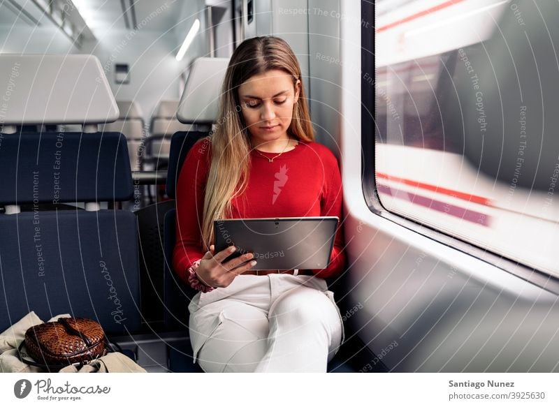 Blondes Mädchen im Zug Tablette reisend Porträt jung 20s Vorderansicht blond hübsch Tablette verwenden Kaukasier Blick Stehen Frau Smartphone Reisender Verkehr