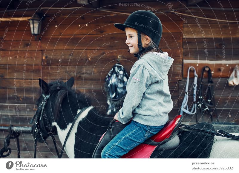 Kleines lächelndes Mädchen lernt Reiten Kind Mitfahrgelegenheit Pferd üben Schule niedlich Land hübsch ländlich Ranch Lektion Reiter Fröhlichkeit lernen
