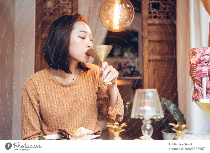 Ethnische Frau, die ein kaltes Getränk während des Abendessens genießt trinken Cocktail Alkohol genießen Kelch Orientalisch Hotel Dienst jung asiatisch ethnisch