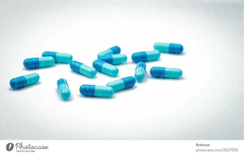 Selektiver Fokus auf blaue Kapselpillen. Gruppe von Kapsel Pillen mit Schatten Verbreitung auf weißem Hintergrund. Apotheke Drogerie Produkt. Gesundheitswesen und Krankenversicherungen Hintergrund. Pharmazeutische Industrie.