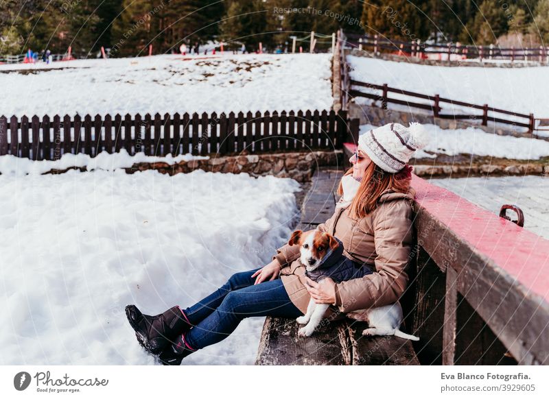 Frau und niedlichen Jack Russell Hund genießen draußen am Berg mit Schnee. Wintersaison Berge u. Gebirge im Freien reisen Lifestyle Fernweh reisend Spaß kalt