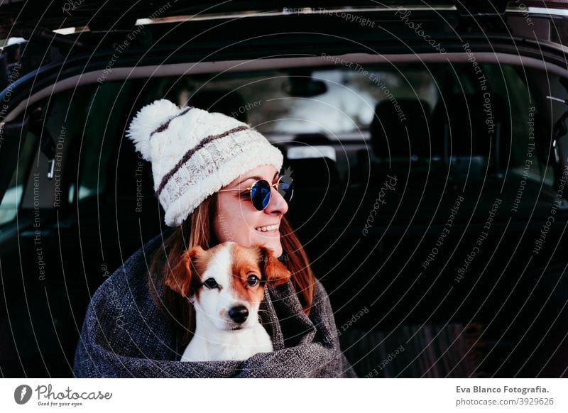 Junge Frau und niedlichen Jack Russel Hund im Auto. Wintersaison, verschneiten Berg Hintergrund Decke Natur Zusammensein Saison Fernweh Schönheit aktiv