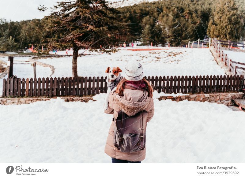Frau und niedlichen Jack Russell Hund genießen draußen am Berg mit Schnee. Wintersaison Beteiligung Schultern Liebe Kuss Umarmung Berge u. Gebirge im Freien