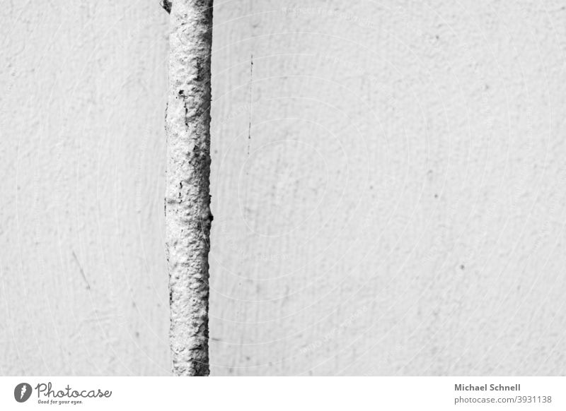 Weißes verrostetes Rohr vor weißer Hauswand weißer Hintergrund Rohrleitung Hausmauer Rust alt Außenaufnahme Fassade grau