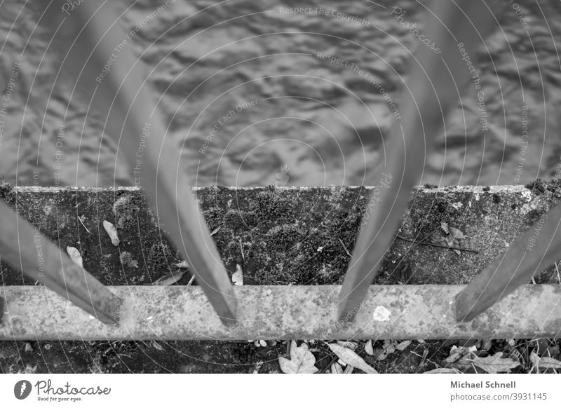 Geländer und Mauer an einem Fluss Wasser fließen Menschenleer Schwarzweißfoto Außenaufnahme Schutz Bewegung Blick nach unten