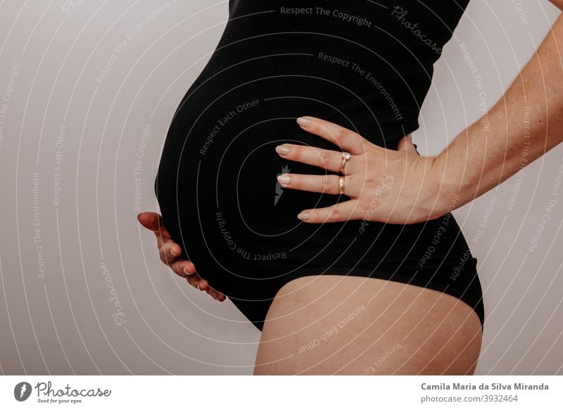 Schwangere junge Frau mit schwarzen Dessous Unterleib Erwachsener Baby Hintergrund schön Schönheit Bauch Körper Blumenstrauß Konzept Textfreiraum erwartungsvoll