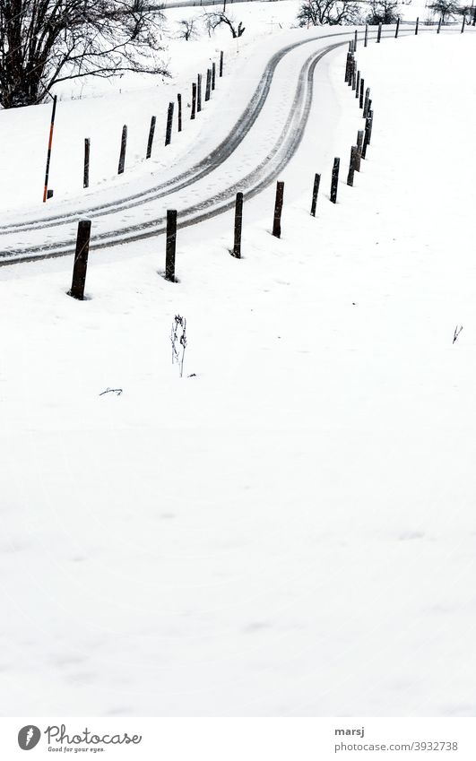 Wenn die Streckenpfosten nicht wären, hätte der Autofahrer die S-förmige, schneebedeckte Straße vielleicht gar nicht gefunden Winterurlaub Schnee eiskalt