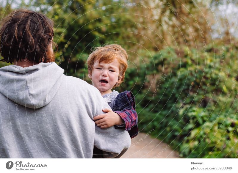 Unglücklich weinendes Kleinkind wird von seinem Vater weggetragen Baby Junge mitgerissen lässig Kaukasier Weinen niedlich Gefahr gefährlich Ingwer