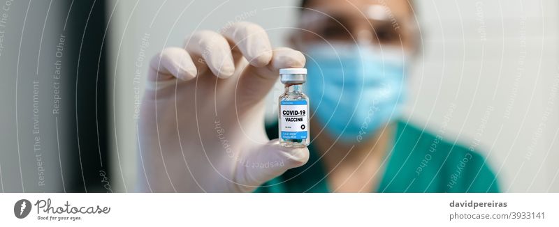 Weiblicher Labortechniker zeigt Fläschchen mit Coronavirus-Impfstoff pharmazeutisches Labor Laborantin zeigend Ampulle unkenntlich medizinisch Medizin