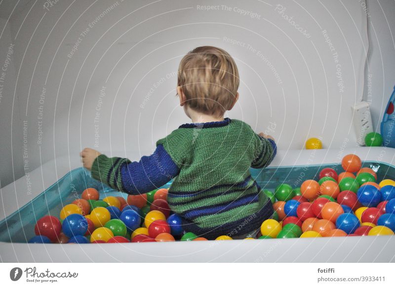 Kind im Bällebad Spielen Spielzeug Ball reichhaltigkeit versunken bunt Kleinkind vertieft rund Kindheit Freude Mensch Glück Aktion Pool Rückansicht