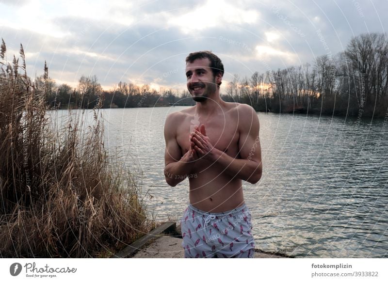 junger Mann in Badehose an einem See im Winter frieren kalt nackt Oberkörper eisbaden Abhärtung Mensch Junger Mann maskulin Gesundheit Mut Tapferkeit muskulös