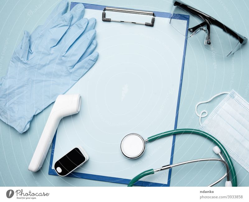 Pulsoximeter und elektronisches Thermometer und anderes medizinisches Zubehör auf blauem Hintergrund Mundschutz Handschuh blanko Zwischenablage Coronavirus