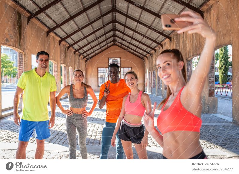 Gesellschaft von fröhlichen Sportlern, die beim Training in der Stadt ein Selfie machen Team Läufer Smartphone heiter Athlet Großstadt Selbstportrait Sommer