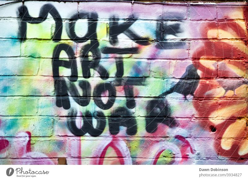 "Make Art Not War"-Zitat in schwarzer Farbe geschrieben Mach Kunst statt Krieg Farbfoto Außenaufnahme Textfreiraum links Zentralperspektive urban Graffiti