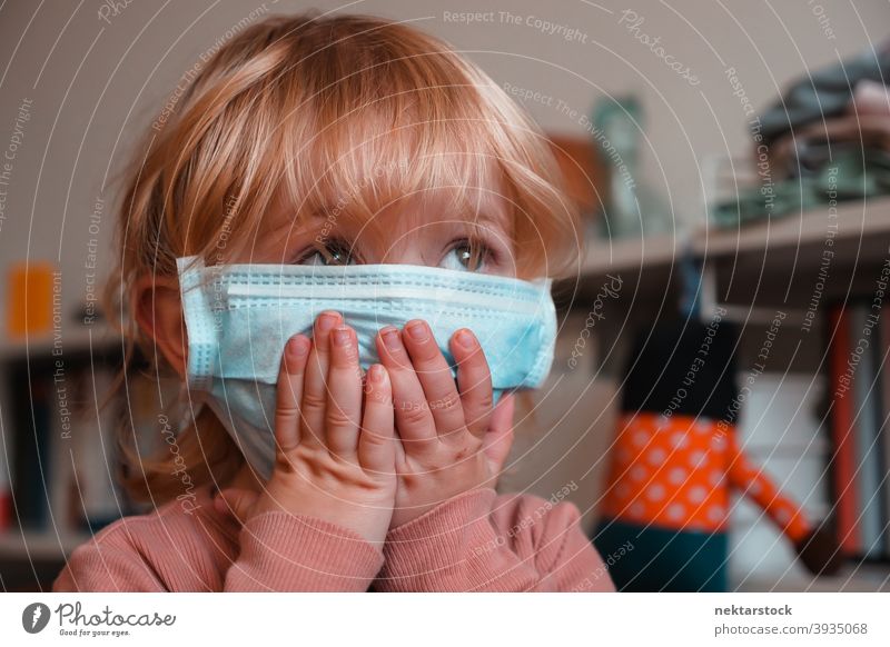 Kind bedeckt Gesicht mit Maske Operationsmaske Gesicht verdunkelt Frau Mädchen im Innenbereich heimwärts zu Hause Mundschutz Kaukasier Gesichtsmaske schützend