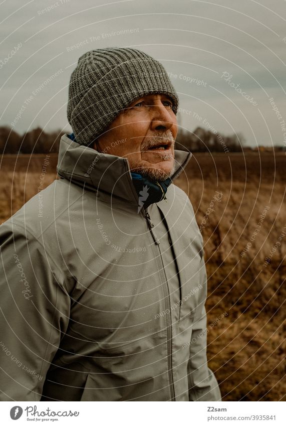 Portrait eines sportlichen Rentners in der Natur spazieren im Freien Sport rentner Ändern Mann Porträt mütze Winter Kälte Landschaft Wald sträucher freizeit