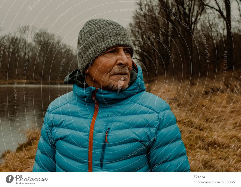 Portrait eines sportlichen Rentners in der Natur spazieren im Freien Sport rentner Ändern Mann Porträt mütze Winter Kälte Landschaft Wald sträucher Isar
