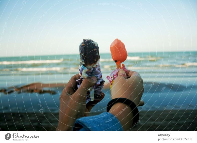 Paar hält Eis am Strand Tag Person Sommer Spaß Erwachsener Hand Speiseeis Freundschaft Frau Dessert Lebensmittel süß horizontal milchig rassenübergreifend