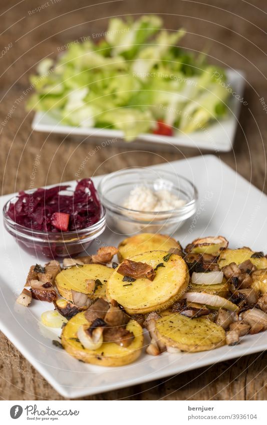 bayerisches Gröstl mit Salat auf Holz Kartoffel Schinken Zwiebel rustikal Kohl Meerrettich BLaukraut Rotkohl groestl geröstet Fleisch Füllung Pilze Mahlzeit