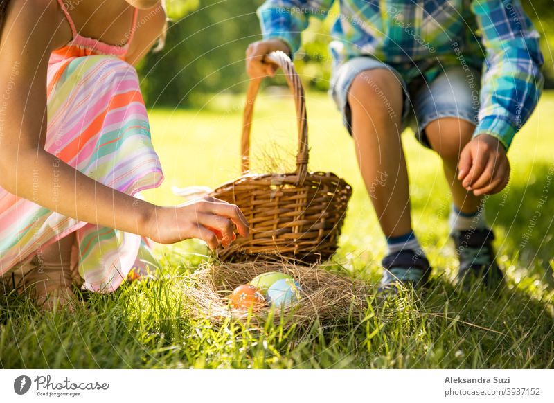 Netter Junge und Mädchen feiern Ostern, suchen und essen Schokoladeneier. Glückliche Familie Urlaub. Glückliche Kinder lachen, lächeln und Spaß haben. Schöner Frühling sonnigen Tag im Park