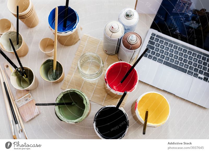 Verschiedene Farben und Pinsel auf dem Tisch Kulisse Pinselblume Werkstatt Atelier kreativ sortiert Glas Spray Laptop verschiedene Handwerk professionell Kunst