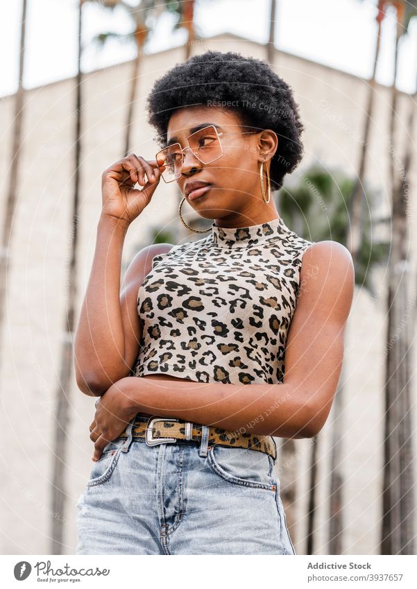 Junge ethnische Frau in trendigem Freizeitoutfit Stil trendy urban Afro-Look Jeansstoff Jeanshose drucken Tier jung selbstbewusst Afroamerikaner schwarz Top