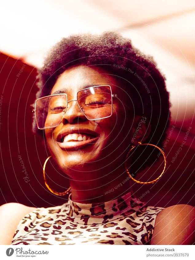 Fröhliche afroamerikanische Frau mit trendiger Sonnenbrille Stil trendy heiter Freude Afro-Look modern jung Lachen Afroamerikaner schwarz Hipster ethnisch