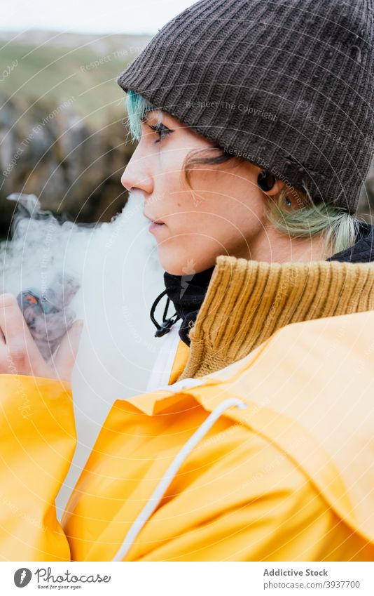 Frau raucht e-Zigarette in der Natur Rauch e Zigarette Raps elektronisch Dunst ausatmen Raucherin Herbst Oberbekleidung Cobijero-Strand Asturien Spanien ruhen