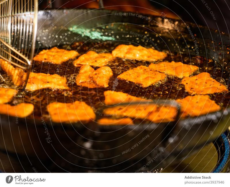 Koch bei der Zubereitung von frittiertem Gebäck Teigwaren tief braten Küchenchef vorbereiten Erdöl kulinarisch Lebensmittel professionell Arbeit Prozess Job