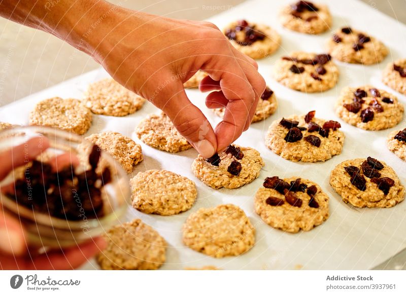 Konditorin macht Kekse mit getrockneten Beeren Gebäck Mürbeteig Konditorei Küchenchef süß vorbereiten kulinarisch setzen hinzufügen Bestandteil Mahlzeit Prozess