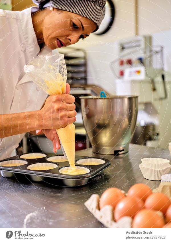 Koch bereitet Muffins in der Küche vor Konditorei Gebäck Küchenchef Teigwaren vorbereiten professionell besetzen Tasche kulinarisch Lebensmittel Frau Arbeit