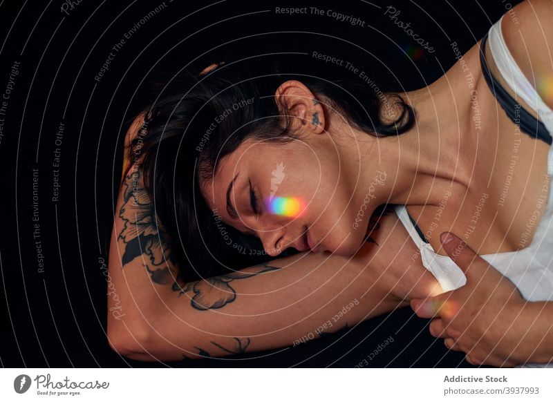 Tätowierte Frau auf dem Boden liegend im Studio Gelassenheit Tattoo verträumt sich[Akk] entspannen Atelier friedlich charmant Harmonie Windstille