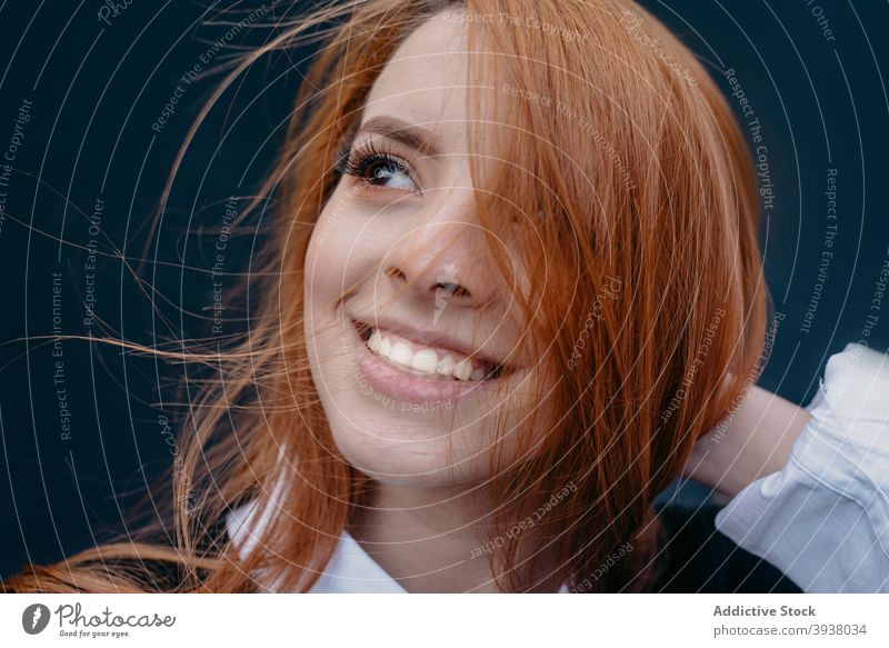Lächelnde Frau mit Wind im Haar auf der Straße Rotschopf Behaarung fliegendes Haar sorgenfrei charmant rote Haare genießen Inhalt jung Ingwer heiter Großstadt