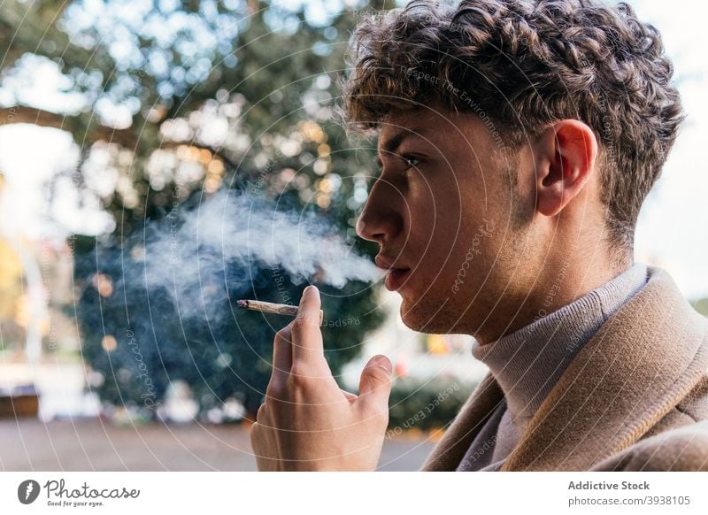 Selbstbewusster Mann raucht Zigarette in der Stadt Rauch Dunst Straße Großstadt Stil Bestimmen Sie ernst Outfit männlich Süchtige Raucherin schlecht Habitus