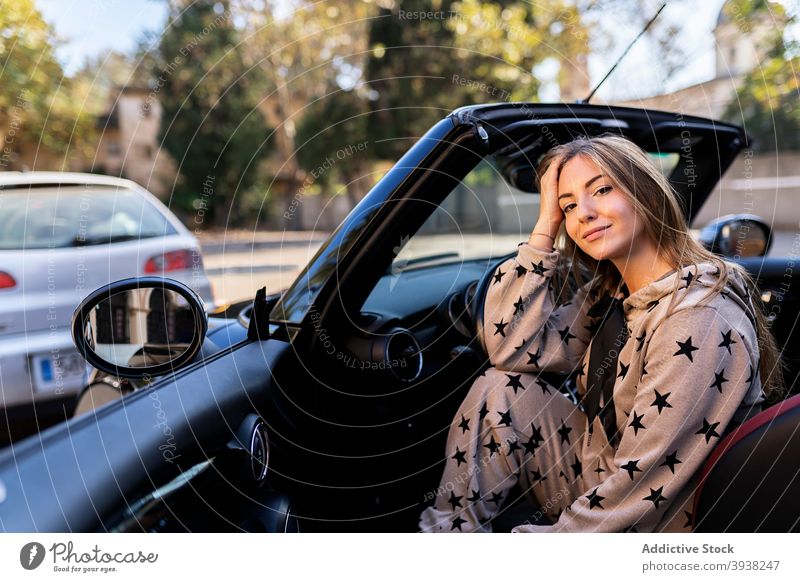 Junge Frau sitzt im Cabrio in der Stadt PKW Stil Automobil Fahrer modern urban Cabriolet jung tausendjährig geparkt Fahrzeug Verkehr Lächeln trendy Dame