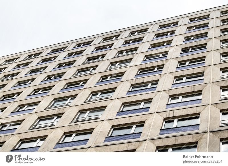eine graue Fassade eines Hochhauses ragt in den Himmel Haus Wohnhaus anonym Fenster Architektur Gebäude Stadt Menschenleer Außenaufnahme Farbfoto Plattenbau