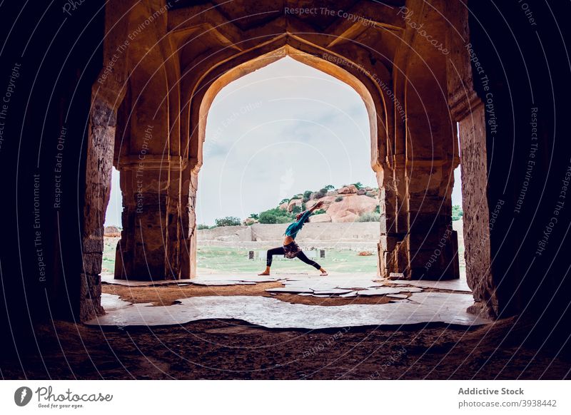Anonyme Dame übt Virabhadrasana Eine Yogahaltung während des Trainings im Freien in der Nähe des historischen Palastes Frau virabhadrasana a Krieger i Zen