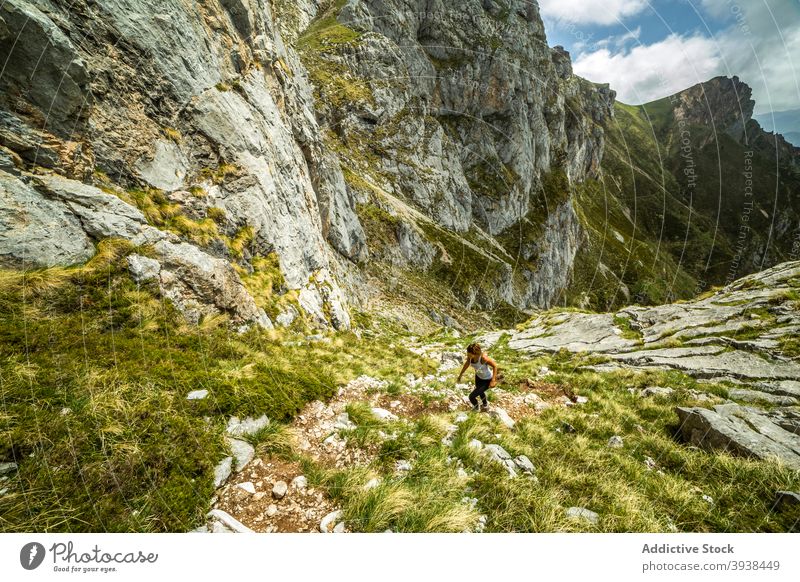 Anonyme weibliche Athletin, die einen felsigen Berg besteigt Frau Spaziergang Berge u. Gebirge Tal Hochland Wanderer Fernweh Natur Aktivität erkunden