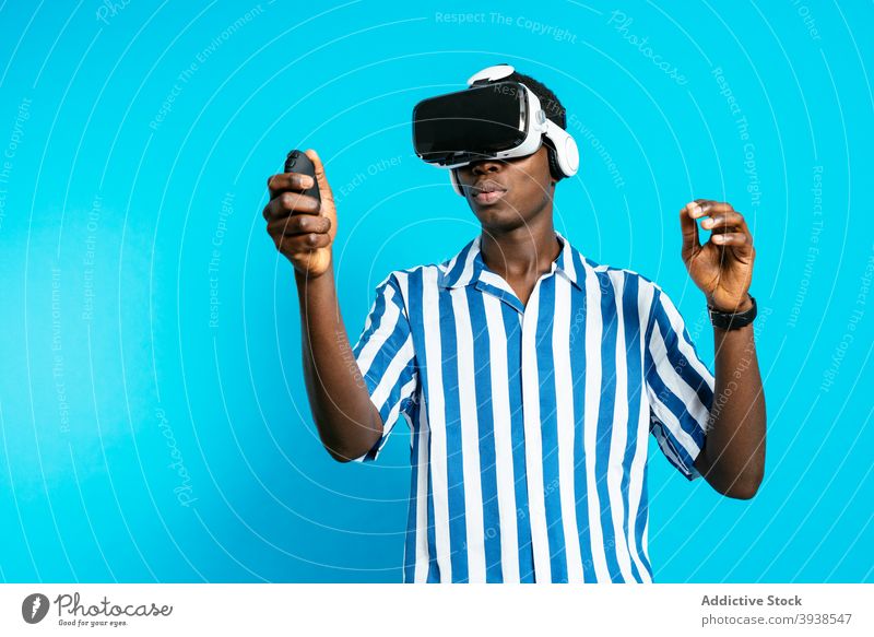 Schwarzer Mann benutzt VR-Headset im Studio Schutzbrille Virtuelle Realität Videospiel spielen Erfahrung virtuell männlich schwarz ethnisch Afroamerikaner