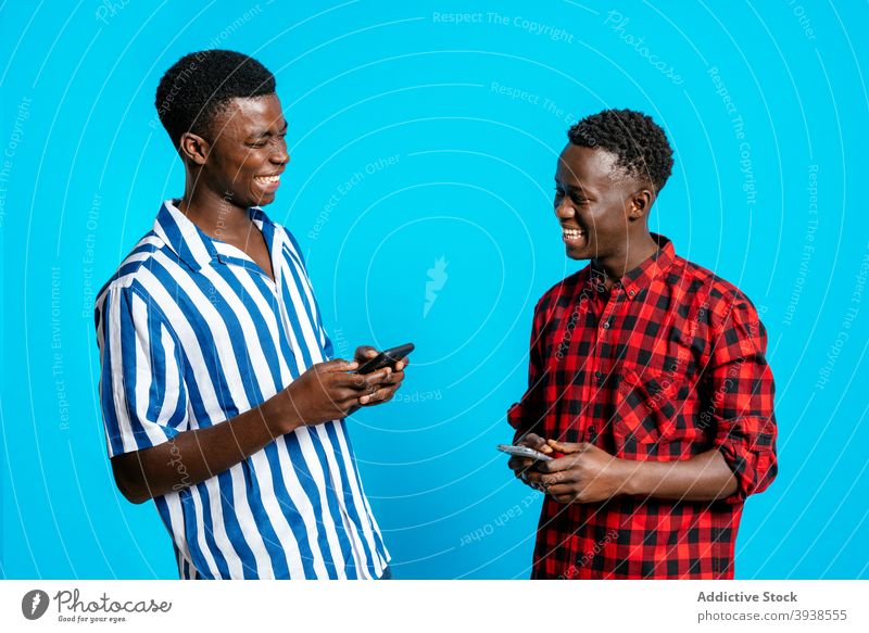 Positive schwarze Männer, die zusammen im Studio lachen bester Freund Lachen Spaß haben Freundschaft Atelier Browsen Smartphone positiv männlich ethnisch