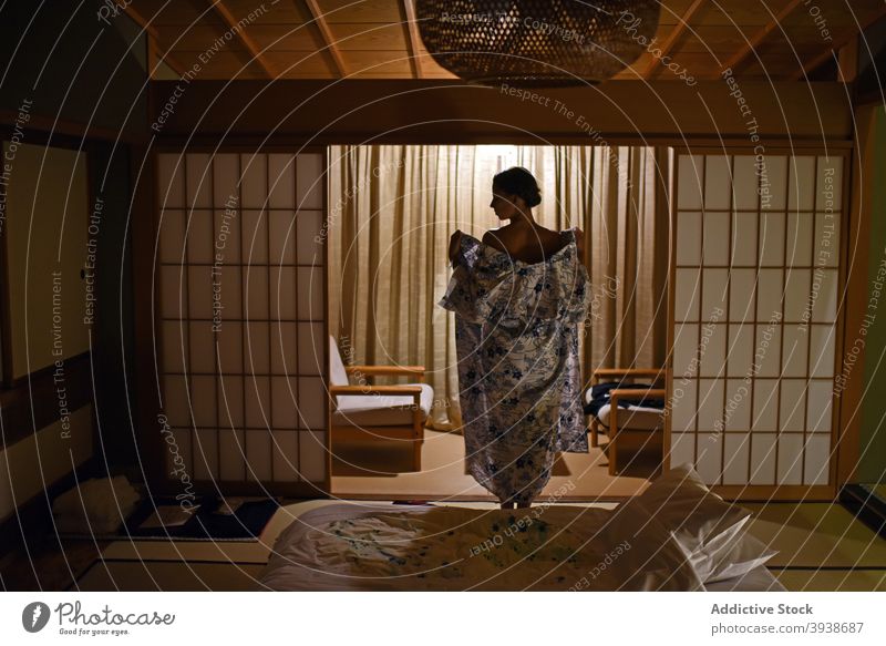 Junge Frau entkleidet sich im japanischen Ryokan-Zimmer 30s jung Kaukasier attraktiv Tourist Tourismus gues