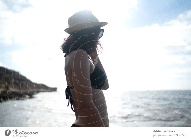 Nachdenkliche junge ethnische Frau entspannt an der Meeresküste gegen bewölkten Sonnenuntergang Himmel sich[Akk] entspannen Meeresufer Urlaub verträumt Erholung