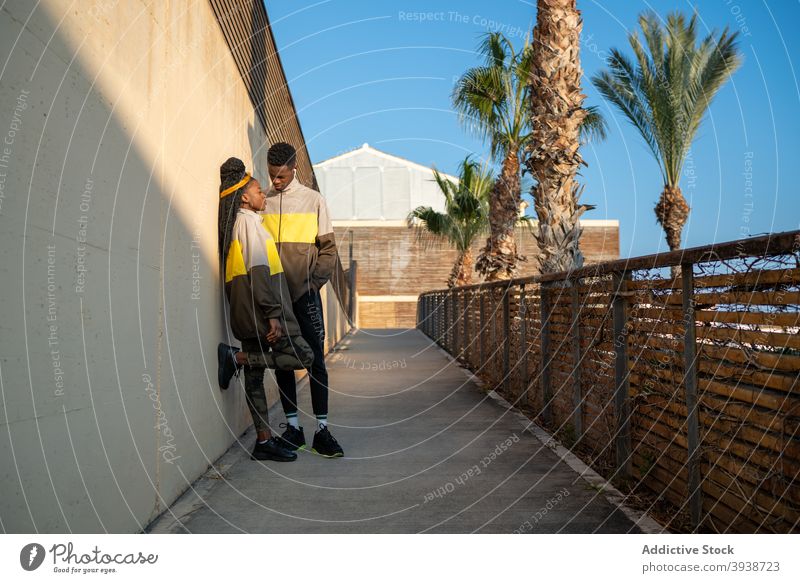 Sportliches schwarzes Paar entspannt sich nach dem Training im Park sich[Akk] entspannen Zusammensein Erholung Pause Partnerschaft Handfläche Stil Vitalität