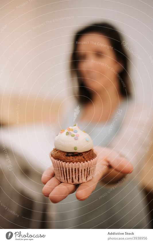 Frau zeigt Cupcake mit Kaffeesahne Konditorei zeigen süß Bonbon Dessert Angebot manifestieren Leckerbissen Café Besitzer positiv freundlich Lebensmittel