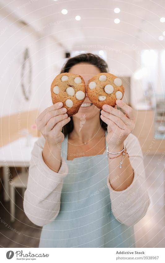 Lustige Frau demonstriert leckere süße Kekse Koch backen Feinschmecker selbstgemacht Chips gestikulieren Beteiligung lustig Spaß niedlich Glück Auge Snack Blick