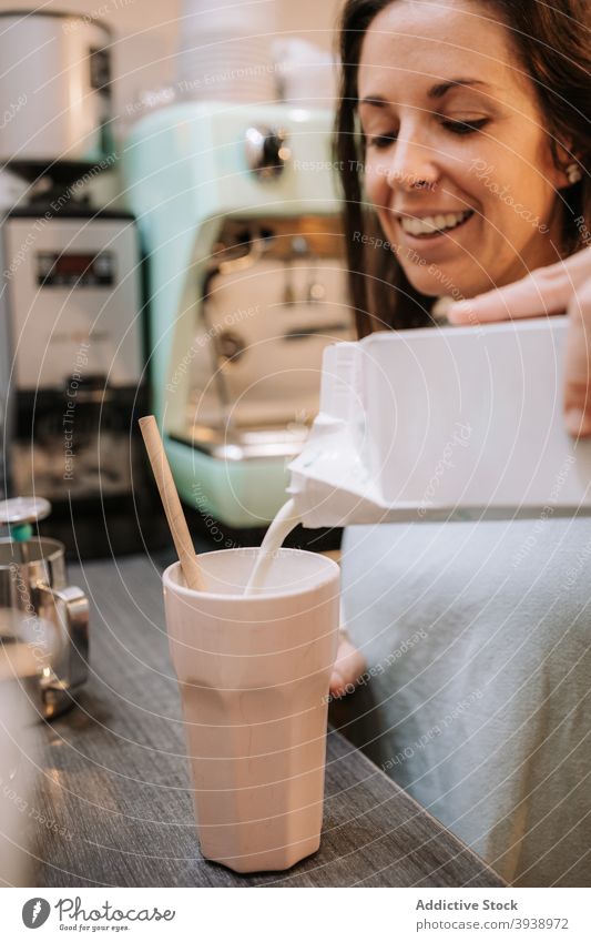 Frau bereitet Milchshake im Café zu melken vorbereiten Barkeeper trinken Getränk eingießen Kantine Abfertigungsschalter Lächeln heiter Barista Job Arbeit