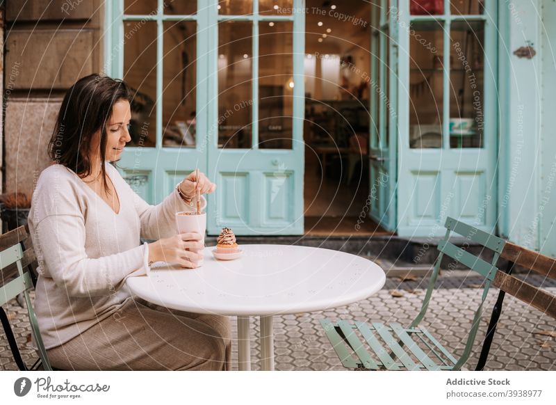 Frau mit Kaffeepause mit Dessert im Café Konditorei Cupcake Bonbon essen süß Kantine Terrasse Lebensmittel geschmackvoll lecker Leckerbissen Kunde gemütlich