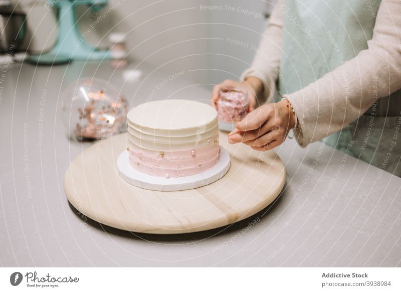 Zuckerbäckerin dekoriert festliche Torte mit Zuckerperlen Konditorei Kuchen dekorieren Perle Dessert süß Sahne Lebensmittel Frau professionell Arbeit Beruf